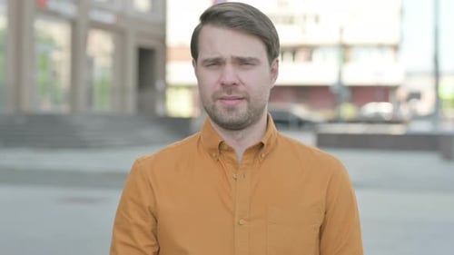 Man Looking Directly at Camera in Urban Setting
