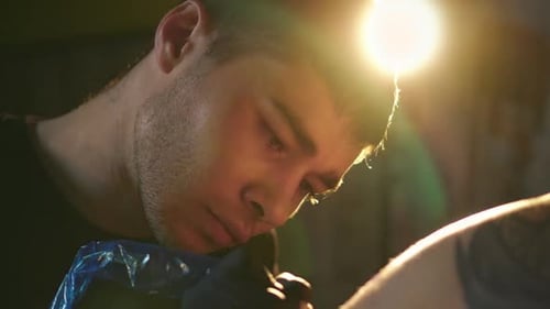 Tattoo Artist Working Carefully on Client Close Up