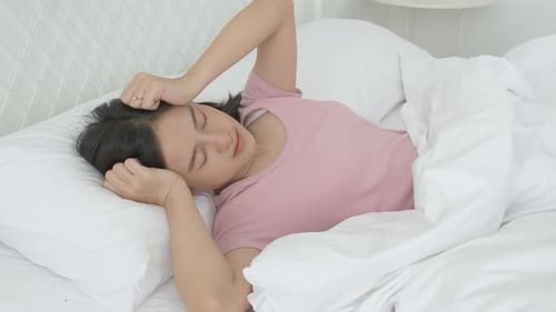 Woman Lying Awake in Bed with a Headache