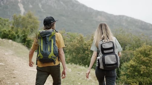 Hiking Couple Walks Down Green Mountain Path