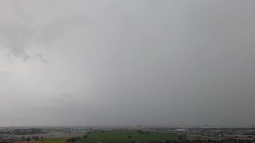 Dark rain and stormy clouds over cityscape, time lapse static view