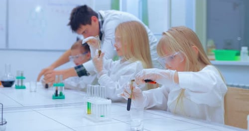 Teacher and Students Doing Science Experiment in School Classroom