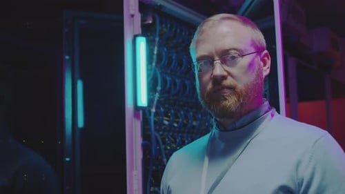 Portrait of Data Center Engineer in Server Room with Neon Light