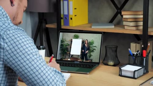 Businessman in Home Study Watch Online Business Webinar Writes in Notebook
