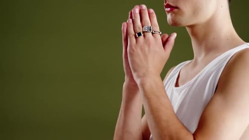 Androgynous man posing against green background