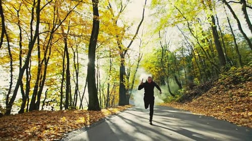 Male with Smoke Flares Running in Forest