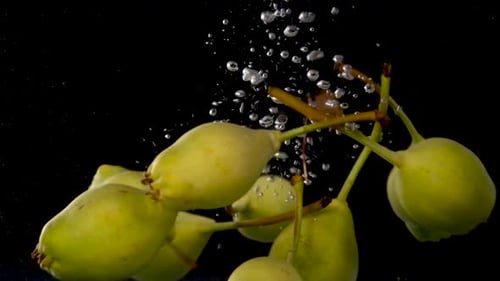 Pears Falling into Water with Bubbles in Slow Motion