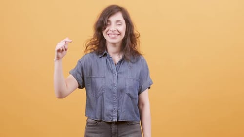 Woman Mimes DJing, Smiles, Makes Hand Gestures