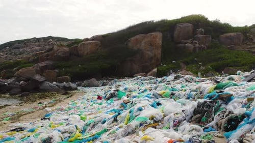 Drone pullback, dirty beach shore filled with plastic ocean trash pollution