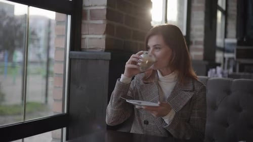 Woman Enjoying Coffee in an Urban Cafe