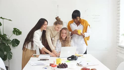 Kreative multiethnische Gruppe von Managern arbeitet zusammen am Laptop