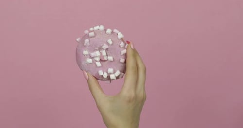 Hand Holding Donut with Marshmallows Close Up