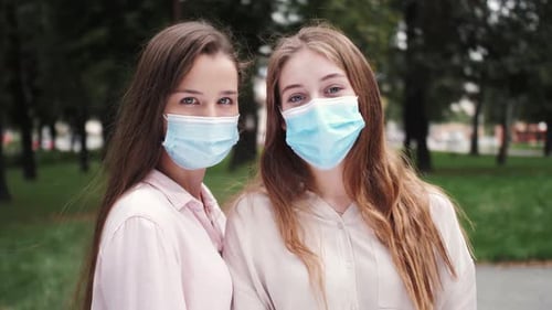 Porträts von Mädchen in medizinischen Masken Zwei Studentinnen mit Schutzmasken Blick auf die