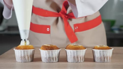 Baker Frosting Cupcakes with Sweet White Icing