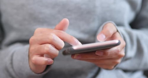 Parte do corpo da mulher usando o celular