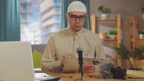 Man with Skull Cap Speaking at Desk