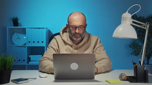 Man Working at Laptop Stretches