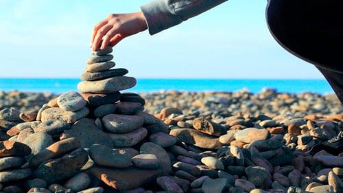 Mujer poniendo la última piedra pequeña en la parte superior