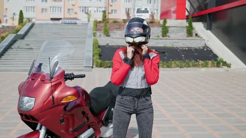 Woman Puts on Helmet and Sits on Motorcycle