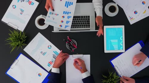 Mitarbeiter sitzen am Schreibtisch und diskutieren Finanzdokumente