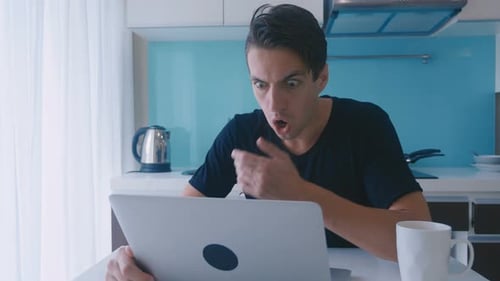 Man Surprised by Computer in Kitchen