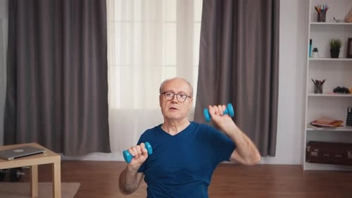 Senior Man Exercising with Dumbbells at Home