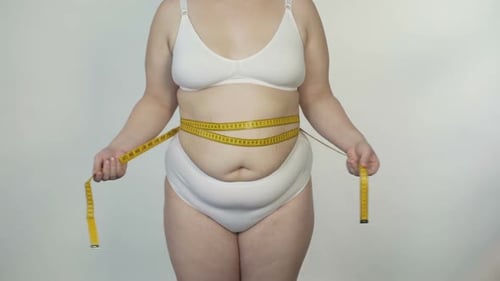 Person Measuring Waist in White Bra and Underwear