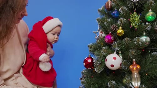 Infant Reaches for Christmas Tree Ornament