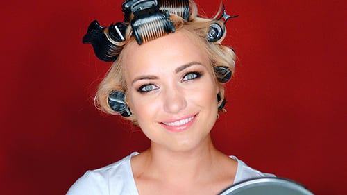 Blonde Woman with Hair Rollers Smiles for Camera
