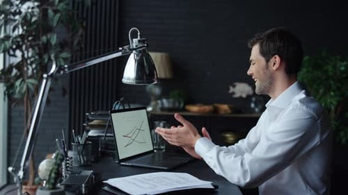 Businessman Working with Graphs on Laptop in Office. Worker Looking at Graphics