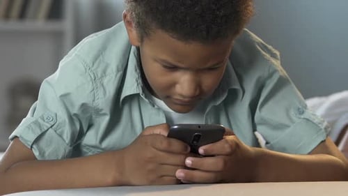 Child Using Mobile Phone Indoors at Home