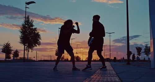 Fighters are Training in City Park in Summer Evening Silhouette Against Beautiful Sunset Prores