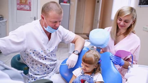 Lovely little girl at the dentist's office. Child stomatologist with his assistant