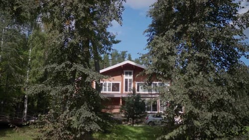 Beautiful Wooden Twostorey House in the Summer in the Forest on a Sunny Day