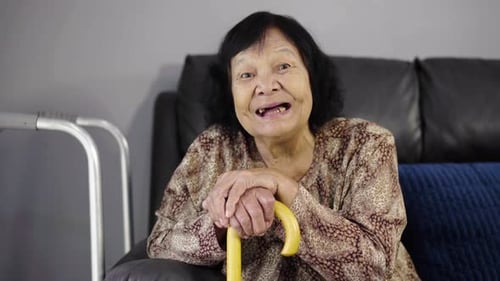 Happy Senior Woman Holding a Cane Indoors