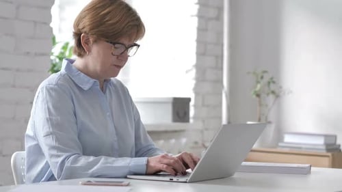 Woman Coughing While Working on Laptop Computer