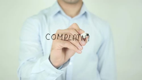 Man Writes Complaint with Marker on Clear Surface