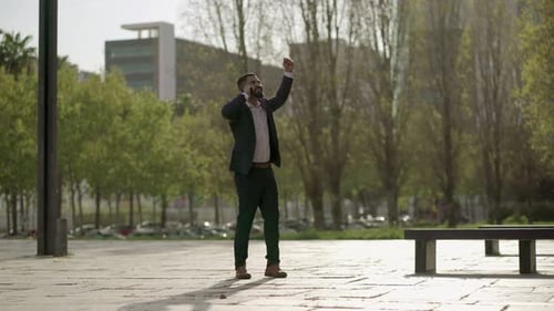 Businessman Celebrating Good News on Mobile Phone Outdoors