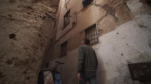 SLOW MOTION: ADVENTUROUS YOUNG MAN EPIC WALKING THROUGH TIGHTS STREETS AND CORNERS IN MOROCCO OLD