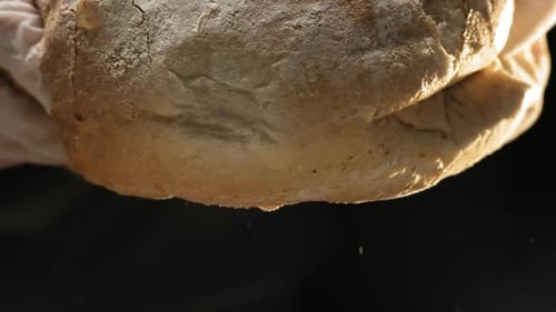 Hand Tearing Fresh Crusty Loaf of Bread