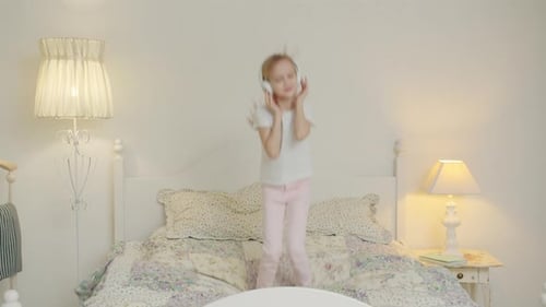 Girl Dancing on Bed with Headphones