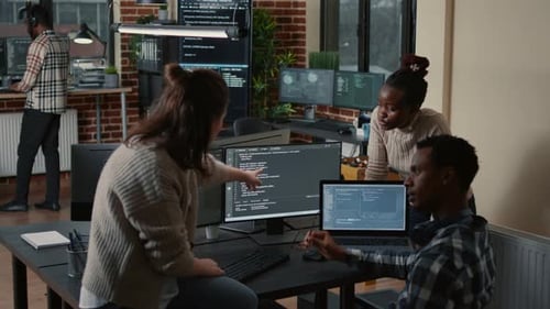 Programador sentado na mesa discutindo com equipe mista de desenvolvedores de software sobre Artificial