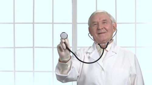 Sehr alter Arzt mit Stethoskop im Krankenhaus.