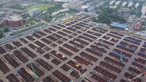 Vista aérea de ocupados trabajadores industriales en construcción que trabajan con grúas y excavadoras