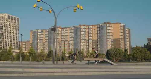 Skateboarders Are Doing Kickflips and Jumps at the Park, Sunny Morning,