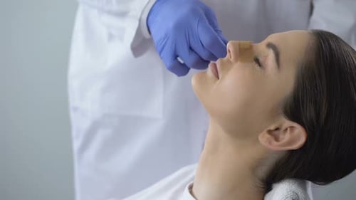 Woman Examining Nose After Cosmetic Procedure