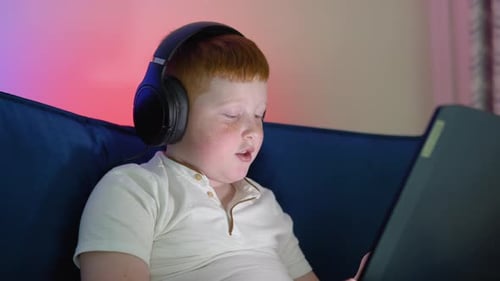 Young Redhaired Boy Student Wear Headset Headphone with Laptop Videocall Talk Present Online