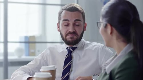 Man and Woman Chat Over Coffee at Work