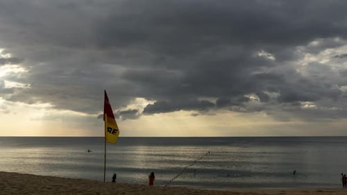 Beach Scene with Dark Clouds and Lifeguard Flag