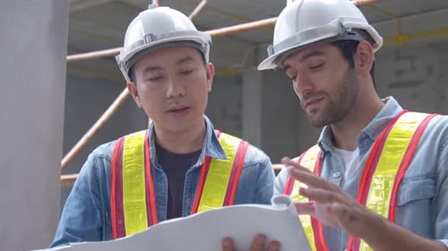 Architects Reviewing Building Plans at Construction Site